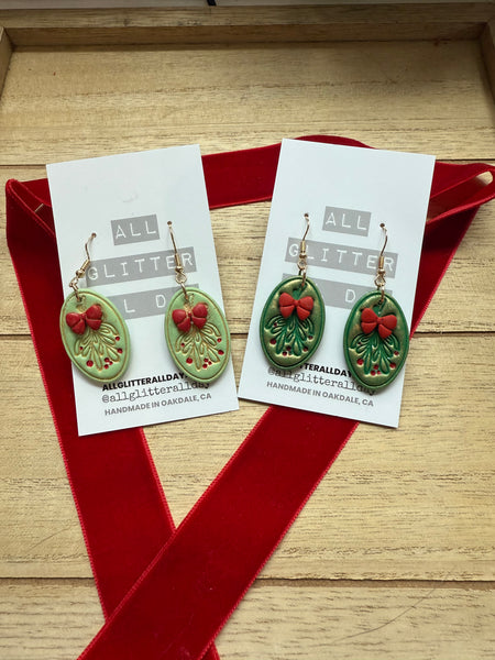 Light green Holly oval dangle with red bow